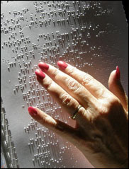 shows a hand reading braille